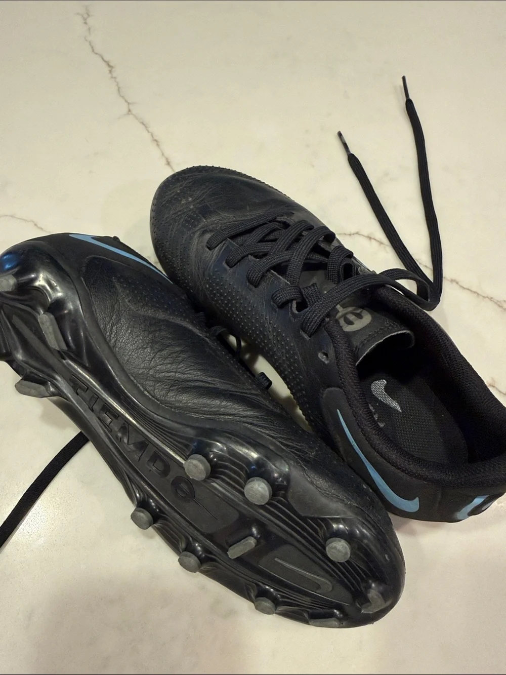 Nike Youth Black Athletic Cleats with Light Blue Swoosh